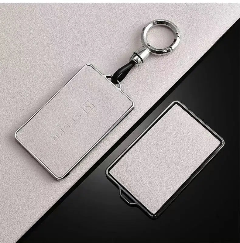 Support de protection NFC argenté avec cordon noir sur fond sombre.