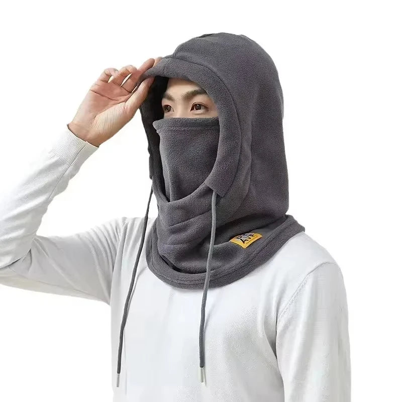 Una persona usando una balaclava y protector de cuello impermeable gris para el invierno.