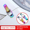A close-up of colorful modified body kit clips used as latch pins for a car hood or bonnet.