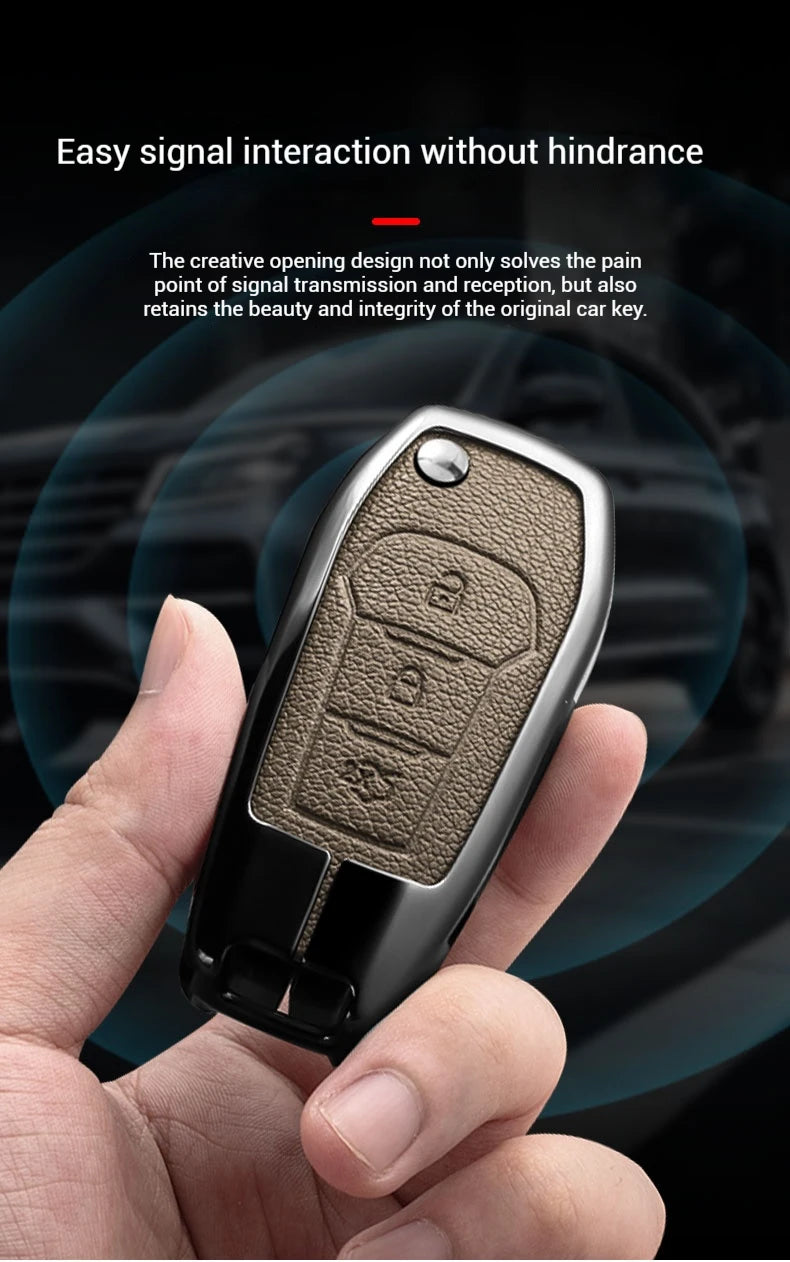 A hand holds an aluminum alloy key fob cover for a Ford vehicle, showing the design and texture.