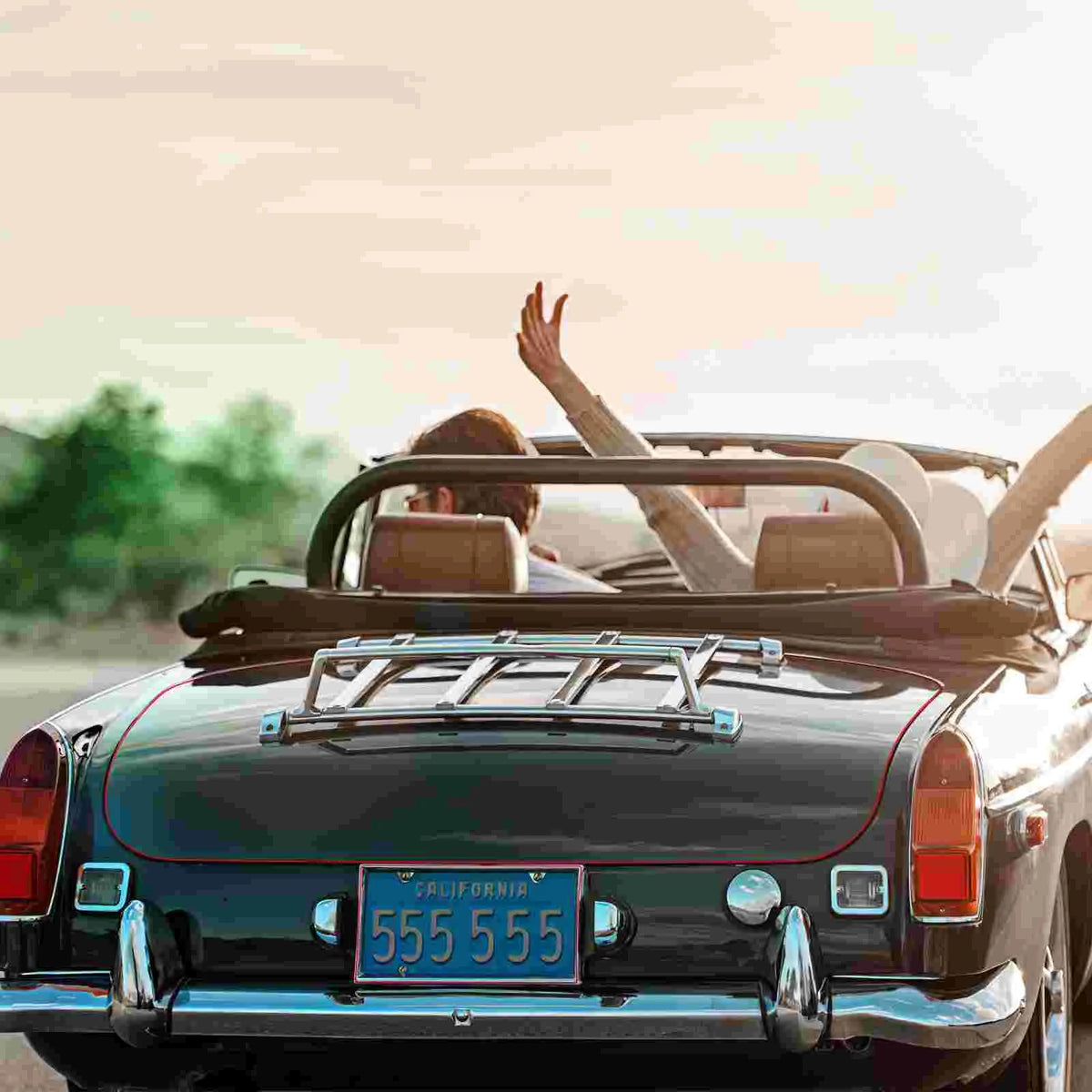 A black convertible car with a silver roof rack and decorative trimming tape on the trunk.