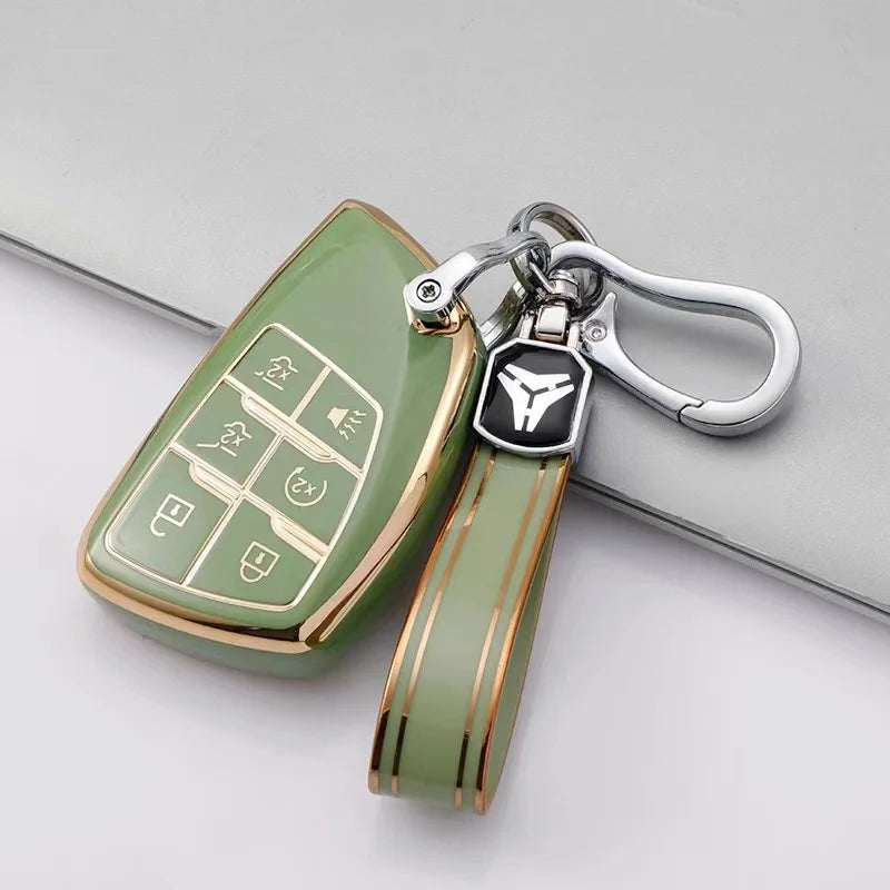 A light green multi-function car key cover with a silver chain and black fob is shown on a gray surface.