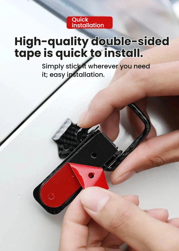 A hand is installing a black latch pin with a red component onto a white surface.
