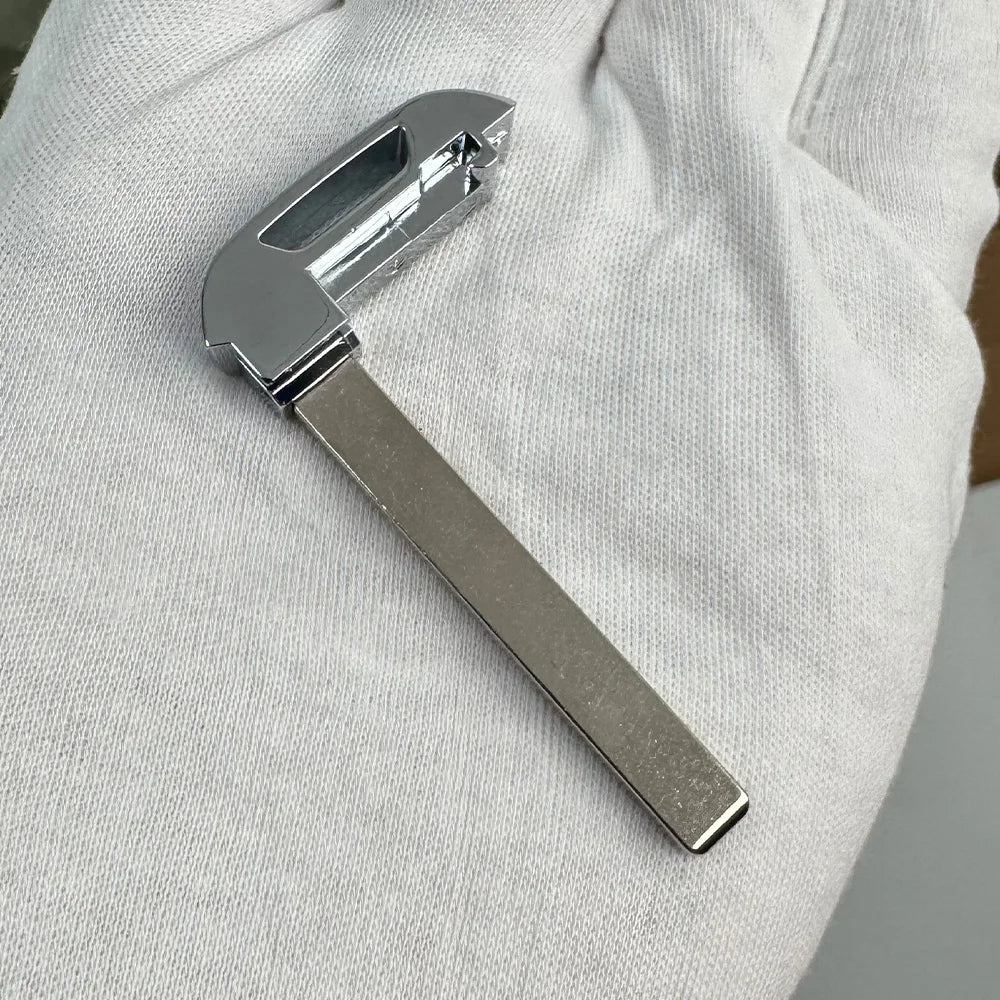 Silver aftermarket remote key for Chevrolet trucks and SUVs held in a hand.