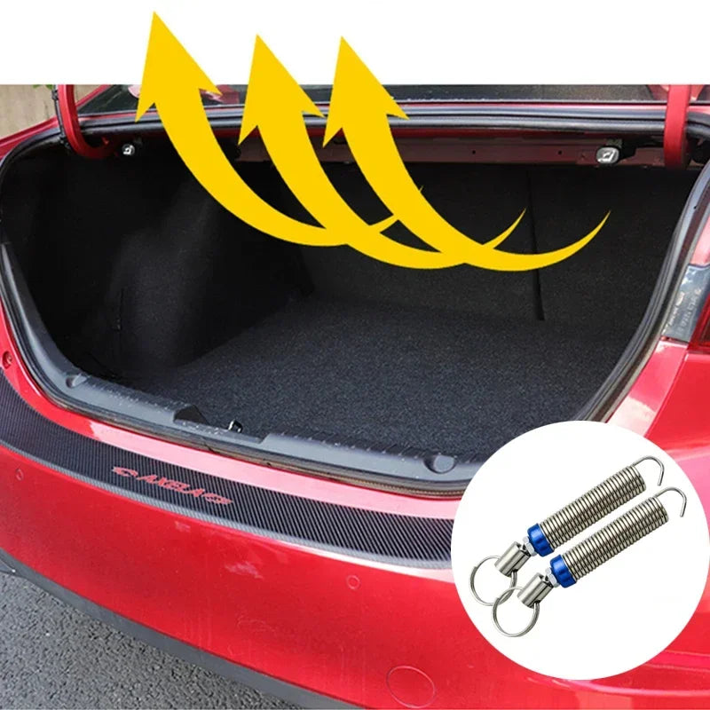 Intérieur du coffre d'une voiture rouge montrant un mécanisme de levage à ressort pour le coffre automatique.
