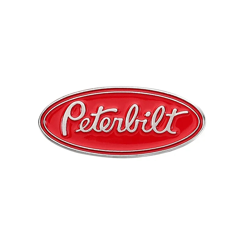 A red oval enamel lapel pin featuring the word Peterbilt in white lettering.