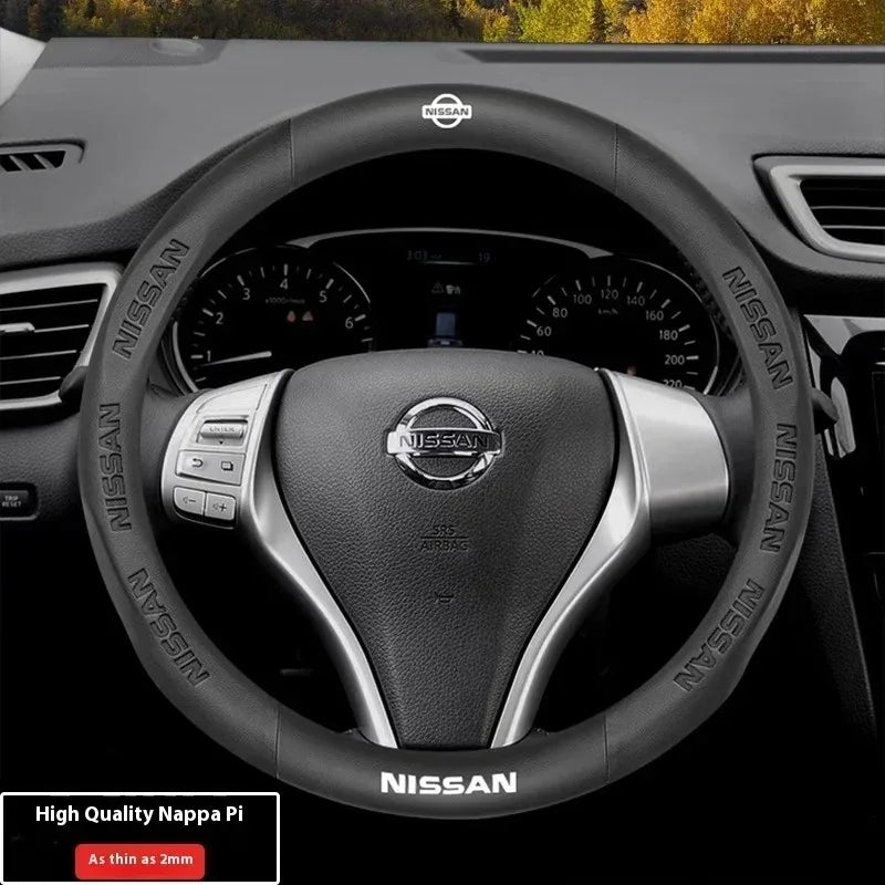 Black Nissan steering wheel cover with carbon fiber accents and a leather grip.