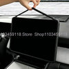 A hand is placing a silicone screen frame protector onto a car display screen.