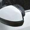 Black anti-fog textured rearview mirror covers mounted on a vehicle's window.