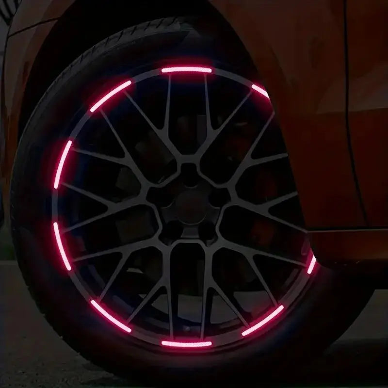Close-up of a car wheel with red LED ring lighting visible through the spokes.