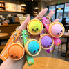 A hand holds several cute silicone keychains shaped like bao buns in various pastel colors and designs.