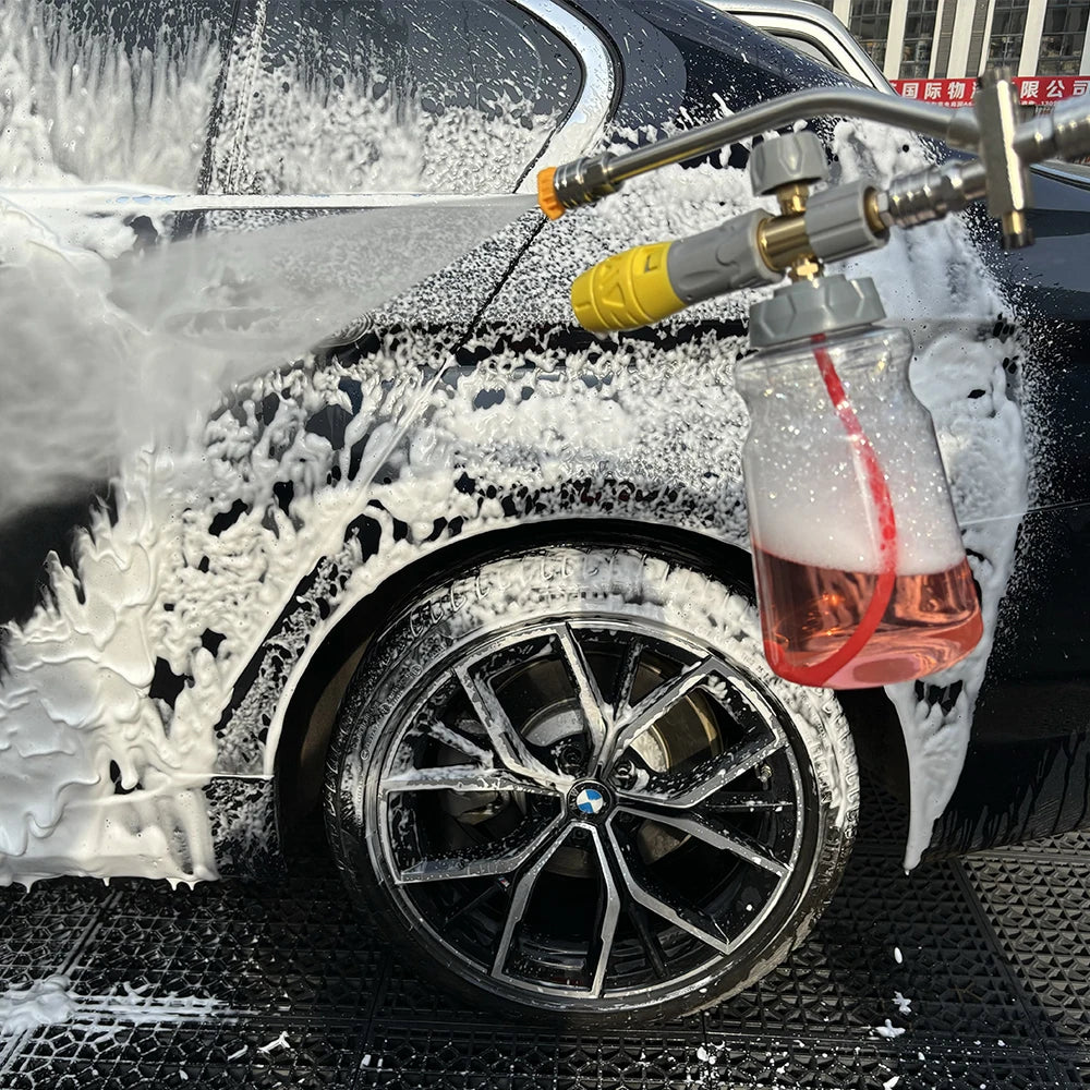 A pressure washer foam cannon adapter is spraying white foam onto a black car's wheel.