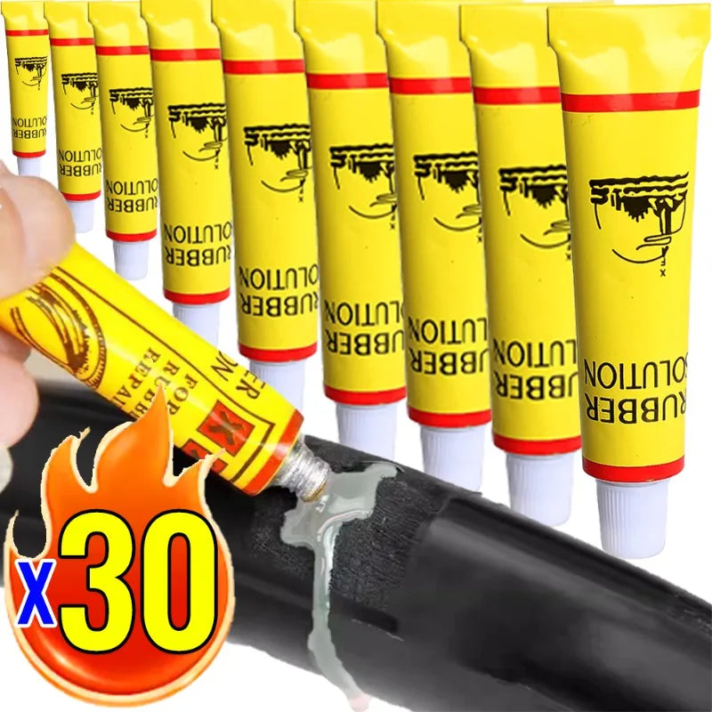 Kit de colle pour réparation de tubes avec plusieurs tubes de colle en caoutchouc jaune et un applicateur noir.