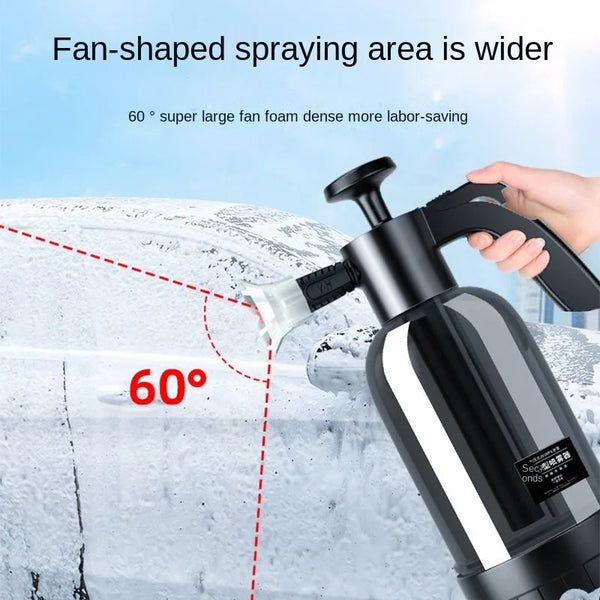 A hand is using a black heavy-duty pump sprayer to apply foam to a window surface covered in ice.