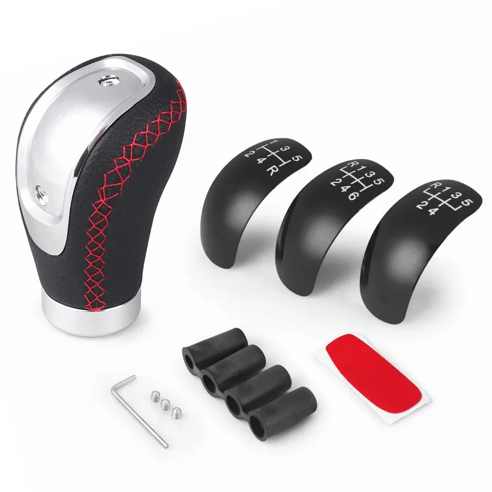 A manual gear shift knob in black and silver with interchangeable speed covers and mounting pins.