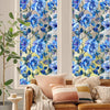 A close-up of a window featuring decorative blue and green floral stained glass patterns.