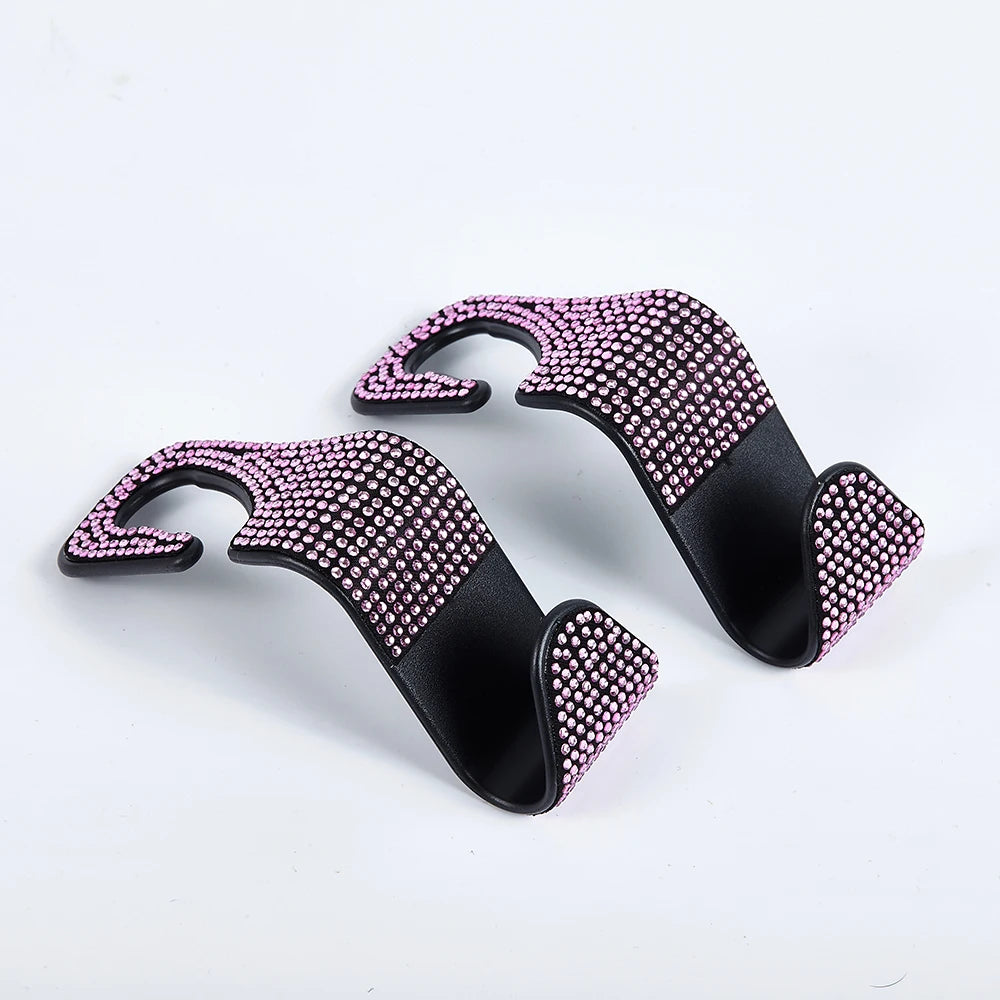 A pair of black car hooks covered in pink artificial diamonds for storage.