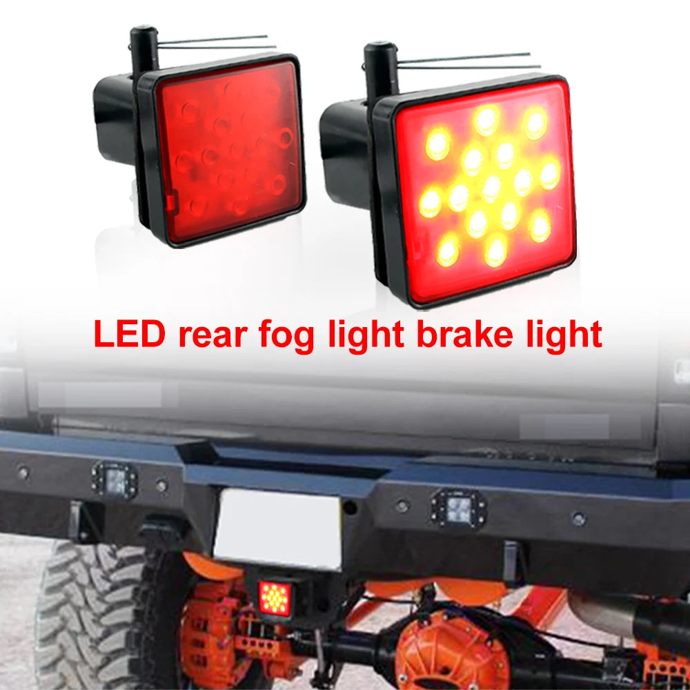 A close-up of a red LED rear fog light brake light mounted on a trailer hitch.