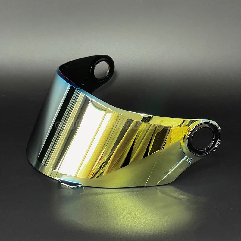 Vista cercana de un visor de casco de motocicleta brillante y tintado de oro que refleja la luz.