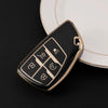 A black multi-function car key cover rests on a white plate.