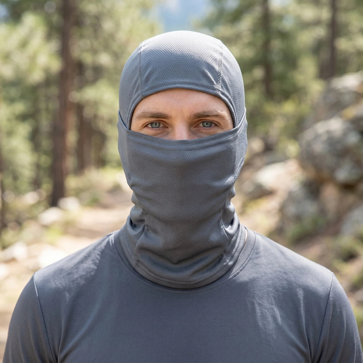 A man wearing a gray multi-functional stretchy balaclava cap for outdoor sports.