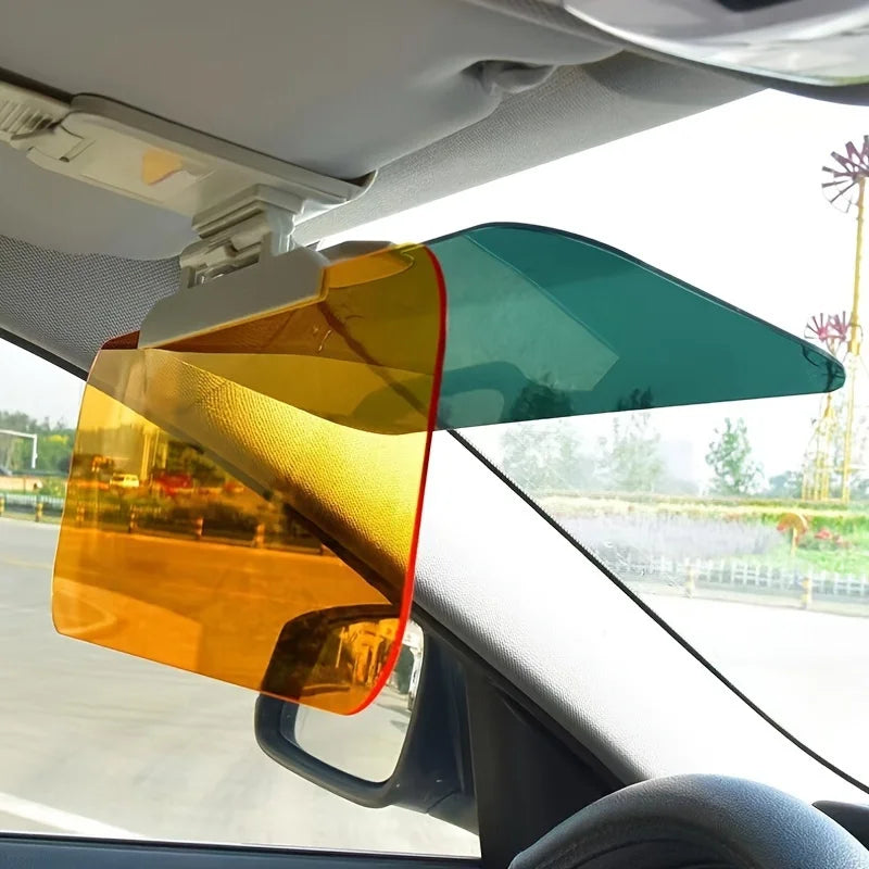 A dual-function anti-glare car sun visor with a split design in orange and teal colors mounted on a vehicle window.