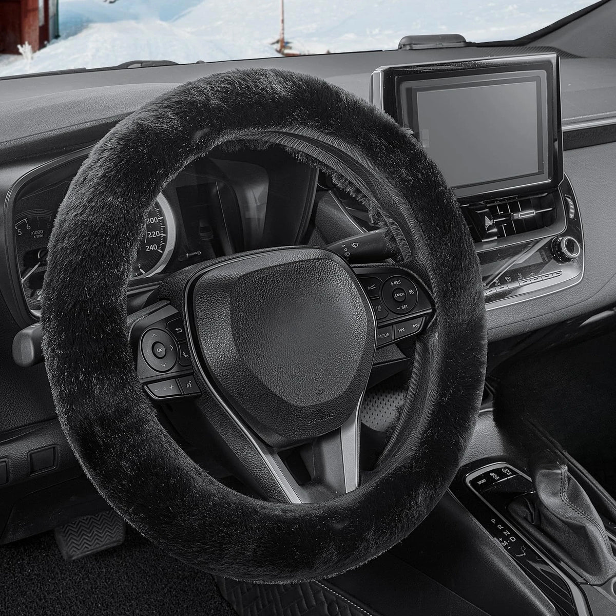 A close-up view of a black winter plush steering wheel cover inside a car interior.