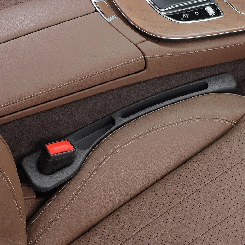 A car seat gap plug and storage organizer is shown in a brown leather interior with a dark plastic insert.