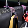 Close-up of black storage hooks with purple glitter accents and a tan leather strap.
