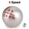 A silver aluminum ball shift knob with red markings showing 6 speed gears and a mounting bolt.