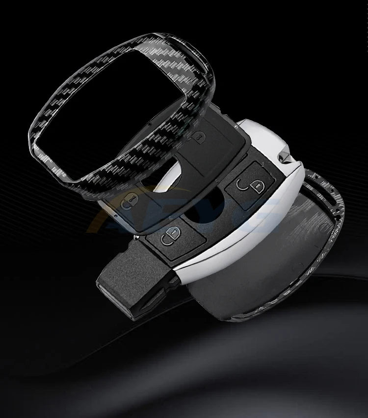 A close-up view of a carbon fiber car key cover for Mercedes models, showing the textured surface and mounting mechanism.