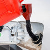 A red funnel is being inserted into a white fuel cap on a car's gas tank.
