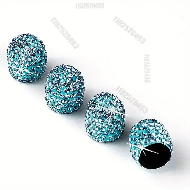 A set of teal and clear crystal diamond finish tire valve caps arranged in a line.