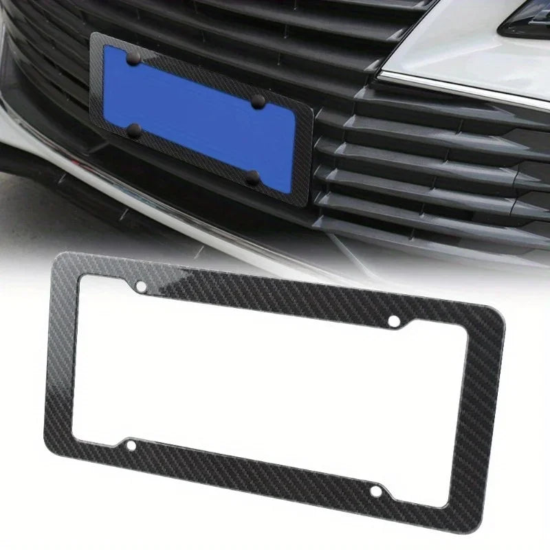 Marco de matrícula de fibra de carbono negra con inserto azul, mostrado en la parrilla de un coche.