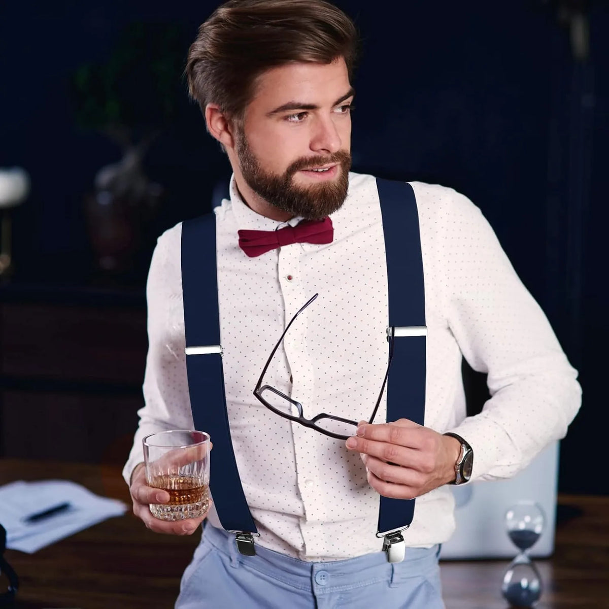 Ein Mann trägt ein weißes Hemd und blaue Jeans und hält schwere Riemen für Männer.