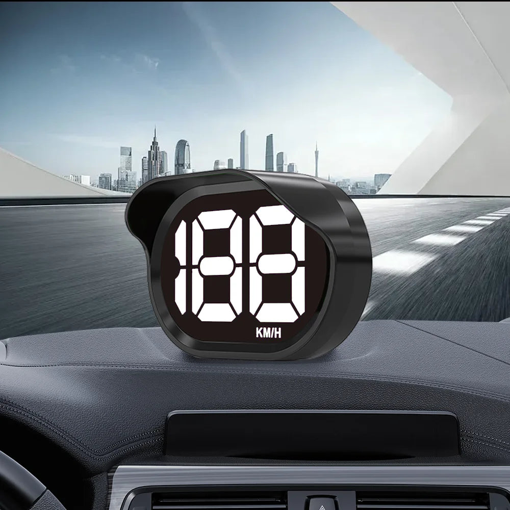 Compteur de vitesse numérique affichant 188 km/h monté sur tableau de bord de voiture avec un paysage urbain en arrière-plan.