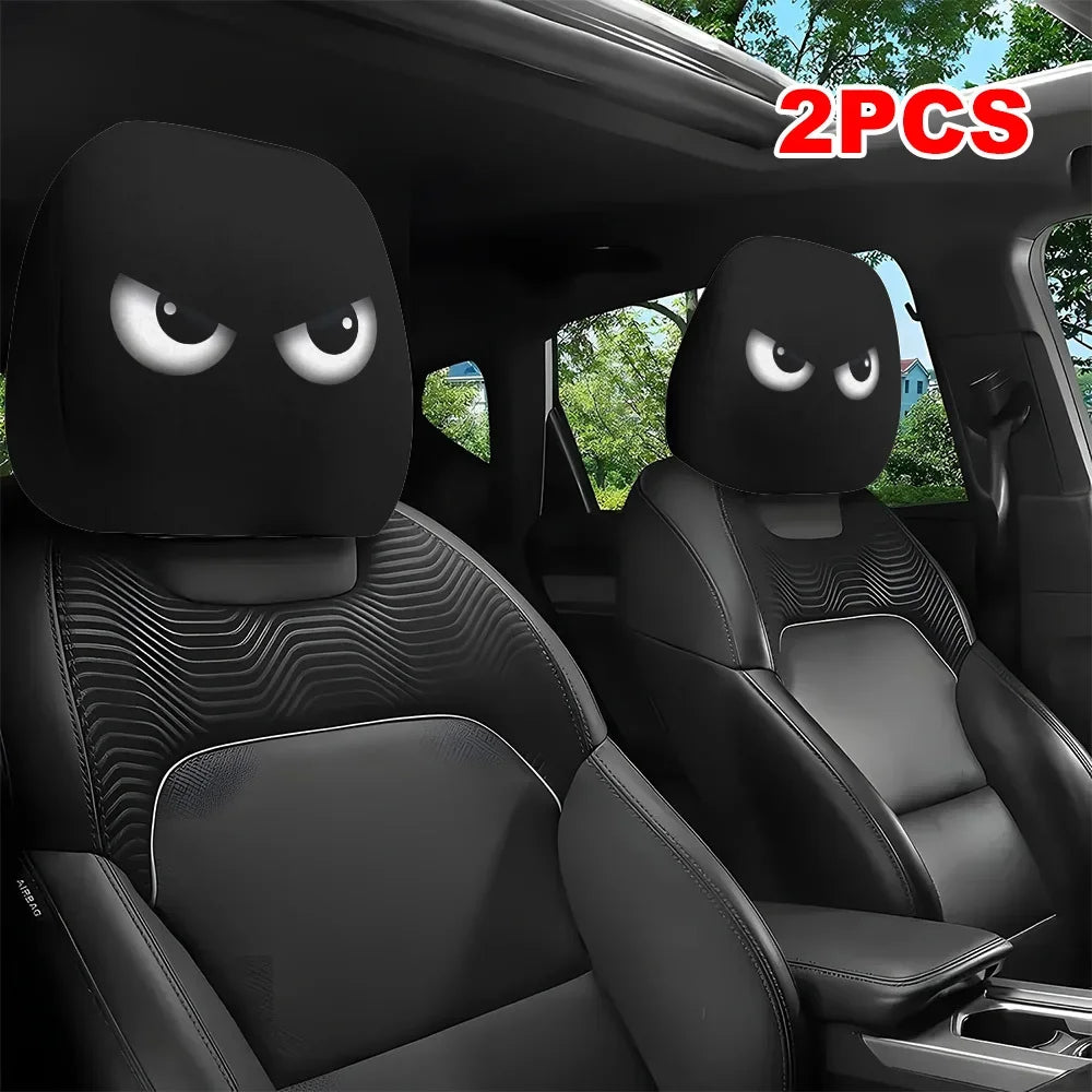 Two black car headrest covers with slanted eyes are shown inside a vehicle cabin.