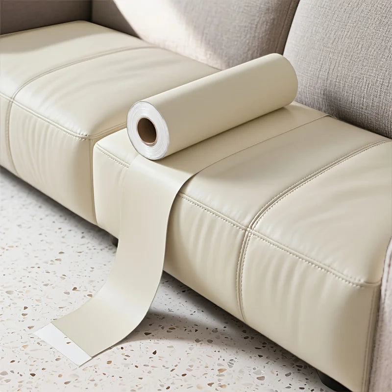 A roll of beige self-adhesive PU leather repair patches resting on a light-colored upholstered surface.