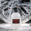 A white heavy duty hand pump foam sprayer bottle with a black pump and nozzle is shown on a snowy surface.