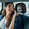 A woman wearing glasses and a blue jacket is looking at a screen displaying a horror face on a car headrest cover.