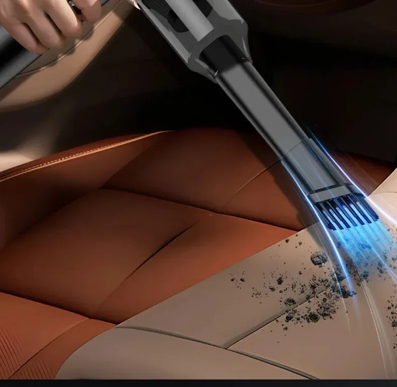 A hand is using a powerful 5-in-1 portable wireless car vacuum to clean dust from a leather car interior.