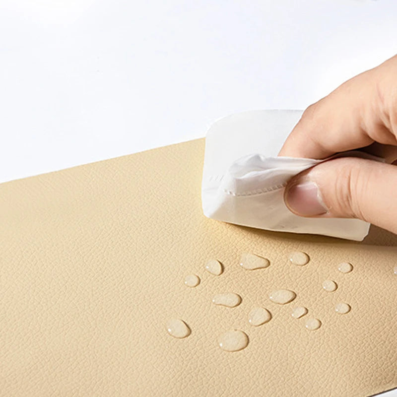 Una mano aplica un parche de cuero PU autoadhesivo sobre una superficie beige.