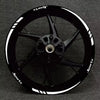 A black sports motorcycle wheel with white reflective decals and spokes.