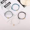 Three heart-shaped fitness tracker bracelets in black, white, and blue are displayed on a white background.