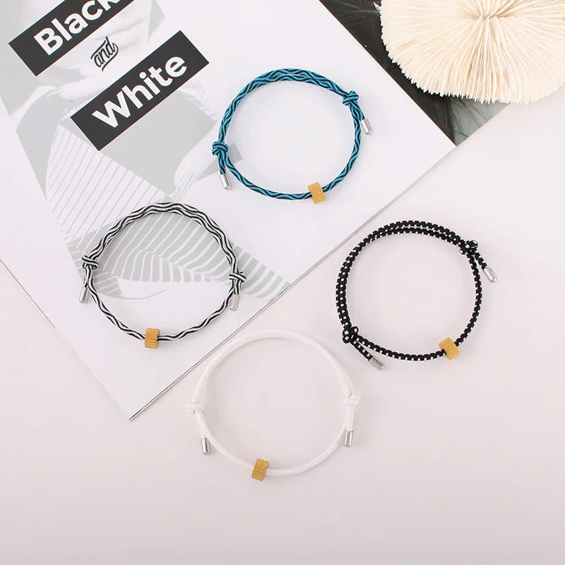 Three heart-shaped fitness tracker bracelets in black, white, and blue are displayed on a white background.