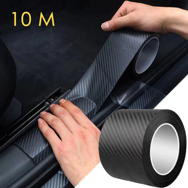 A hand is applying or inspecting a roll of black carbon fiber protection film for car body on a dark surface.