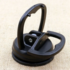 A black suction cup dent puller tool resting on a light-colored fabric surface.