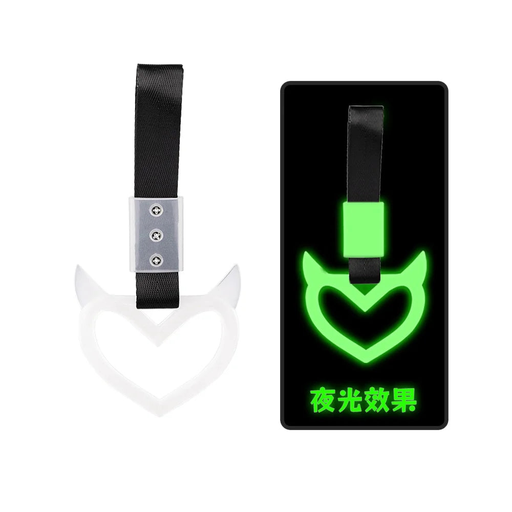 A black handle accessory with a glowing green heart symbol on a black background.