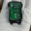An aftermarket remote key for a vehicle is held in a hand, showing the electronic components and casing.