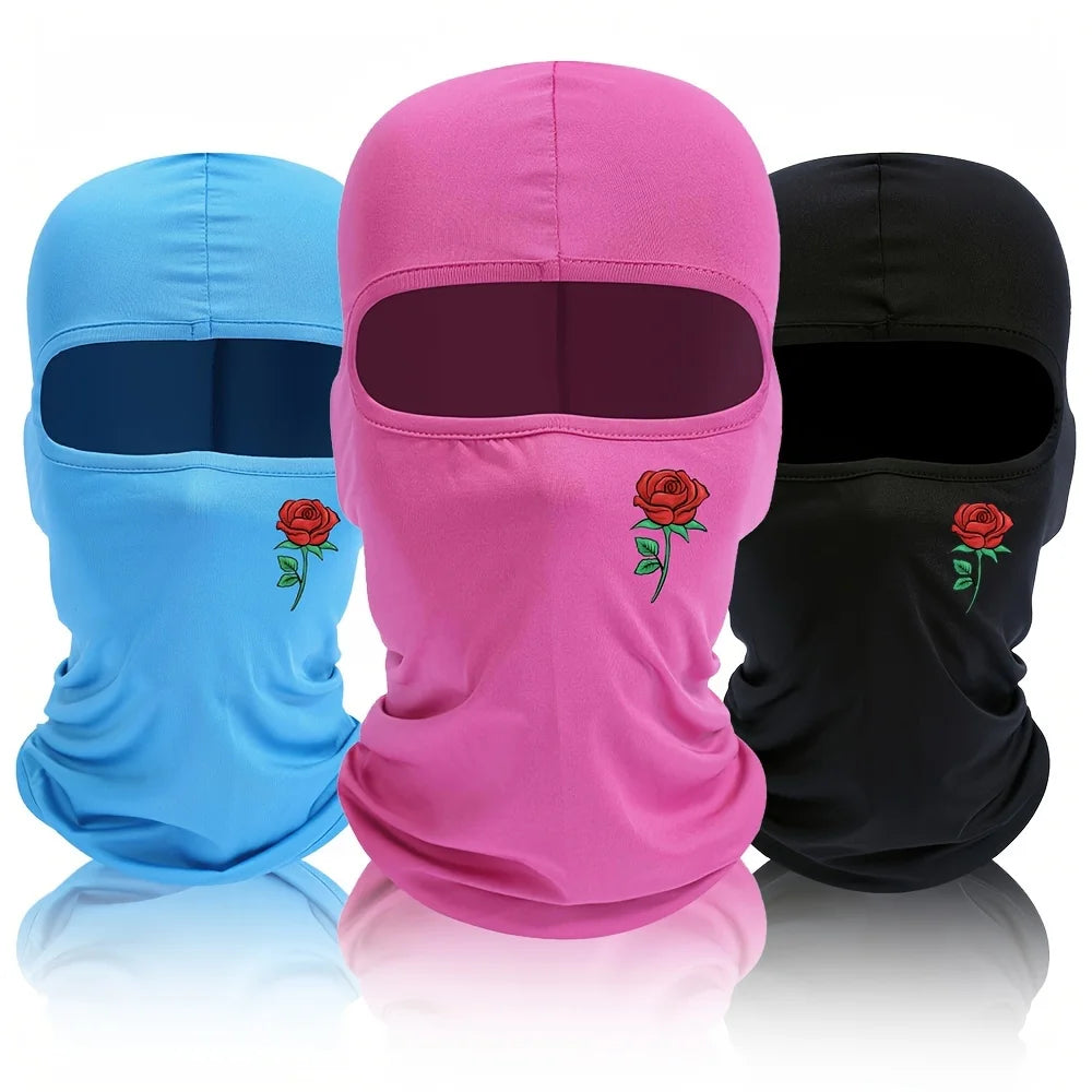 Three balaclava hats in blue, pink, and black with floral designs displayed side by side.